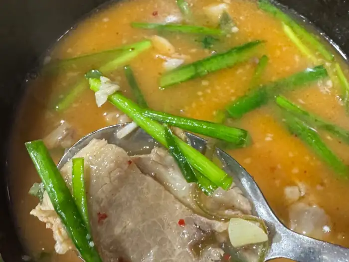 국물에 붉은 양념과 파가 어우러진 순대국밥 클로즈업