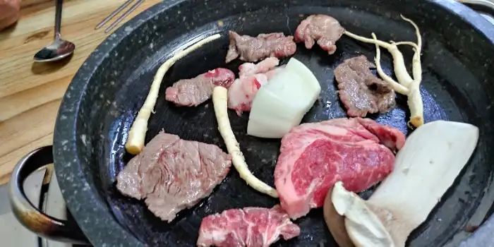 석쇠 판 위에 구워지고 있는 다양한 소고기 부위