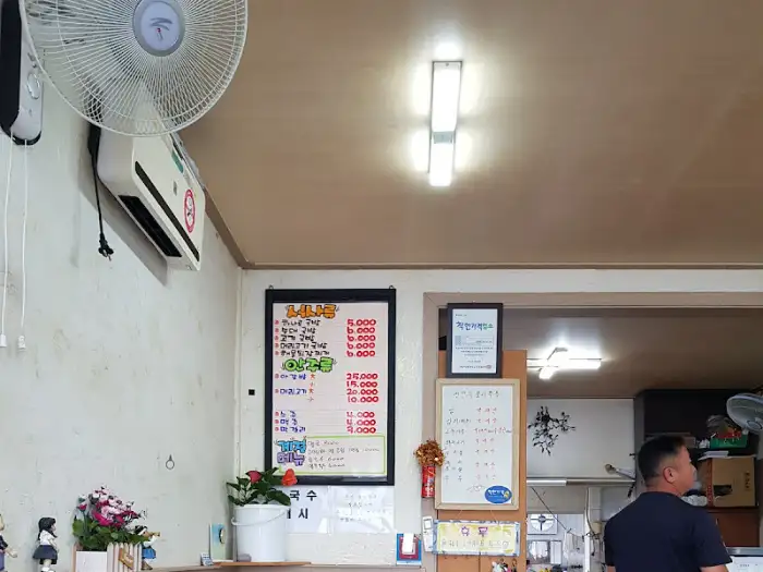 가게 내부 벽에 걸린 메뉴판. 심플하지만 국밥 종류와 가격이 명확하게 적혀 있습니다.