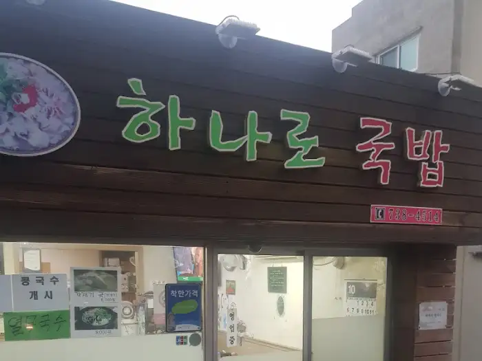 가게 외관의 '하나로 국밥' 간판. 나무 재질의 간판에 초록색과 빨간색 글씨로 상호명이 쓰여 있습니다.