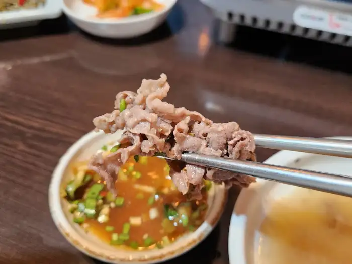 어복쟁반 고기를 양념장에 찍어 먹는 모습