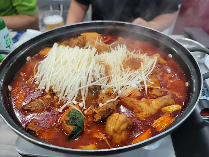 넓은 냄비에 푸짐하게 담긴 닭볶음탕, 닭 조각과 채소가 붉은 국물에 잠겨 있다