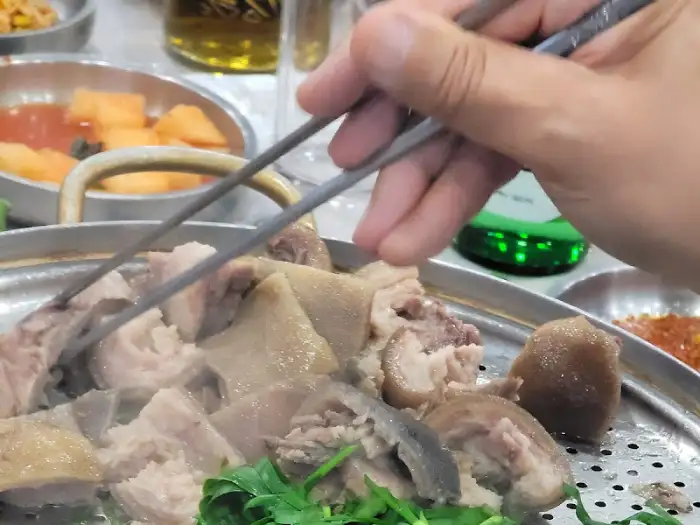 젓가락으로 보신탕 고기를 집어 올리는 모습