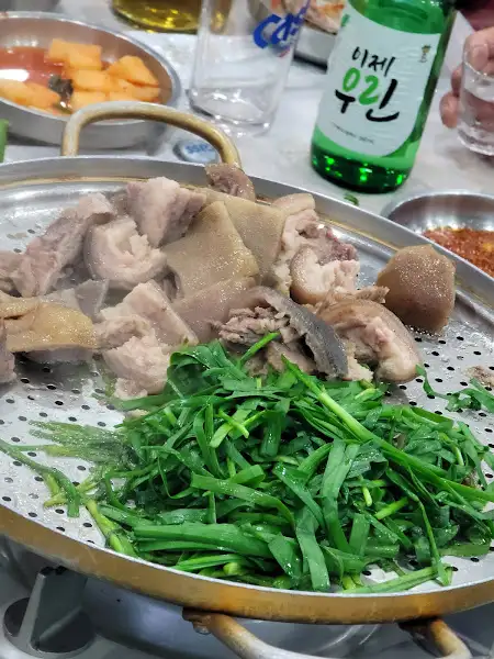 찜기 위에 놓인 돼지 수육과 푸른 채소