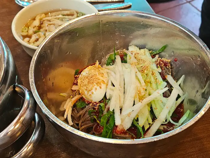 신선한 채소와 고명이 올라간 비빔 메밀면