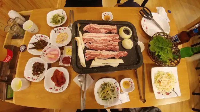 테이블에 차려진 삼겹살 구이와 다양한 반찬들