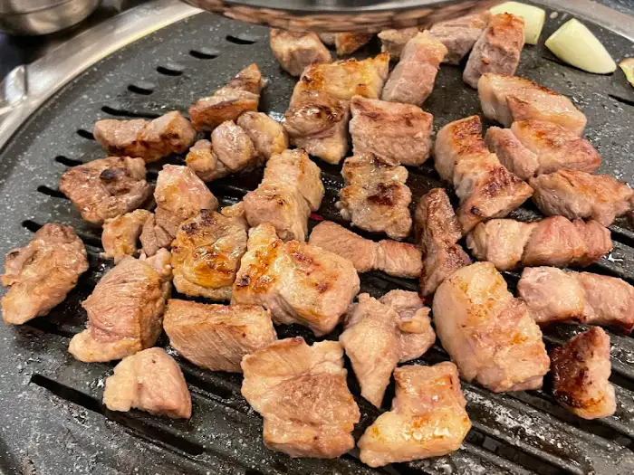 잘 익은 고기 조각들이 불판 위에 가득 채워져 있음