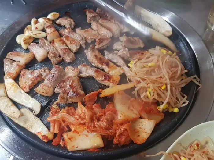 뒷고기와 김치, 콩나물이 함께 구워지는 모습