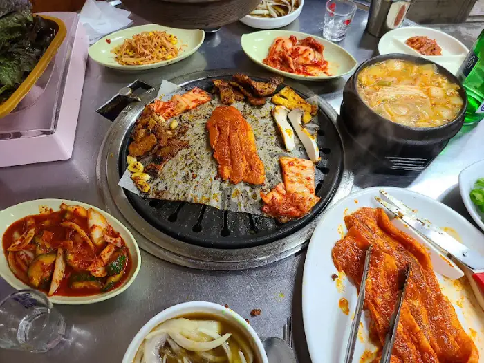 다양한 고기와 찌개, 밥이 함께 차려진 테이블