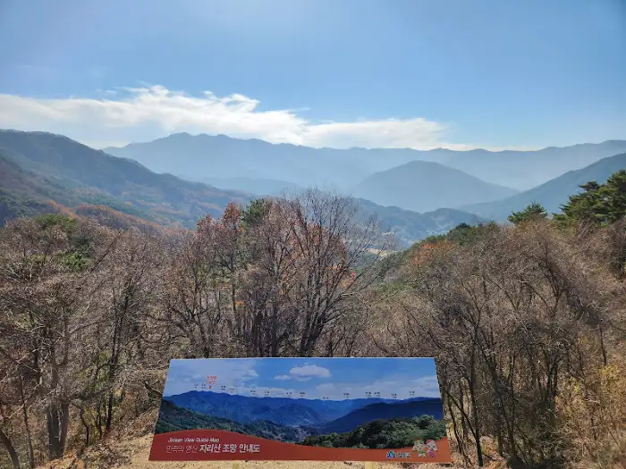 가을 단풍으로 물든 산과 안내 표지판이 보이는 풍경