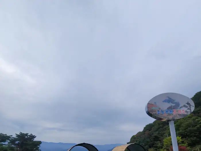 흐린 하늘 아래 보이는 산과 야외 좌석 일부