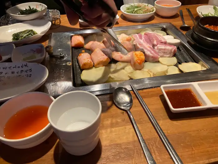 테이블 위에 놓인 음식들과 쌈을 싸고 있는 모습