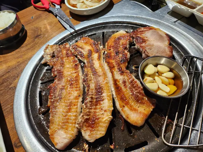 불판 위에서 맛있게 익어가고 있는 삼겹살