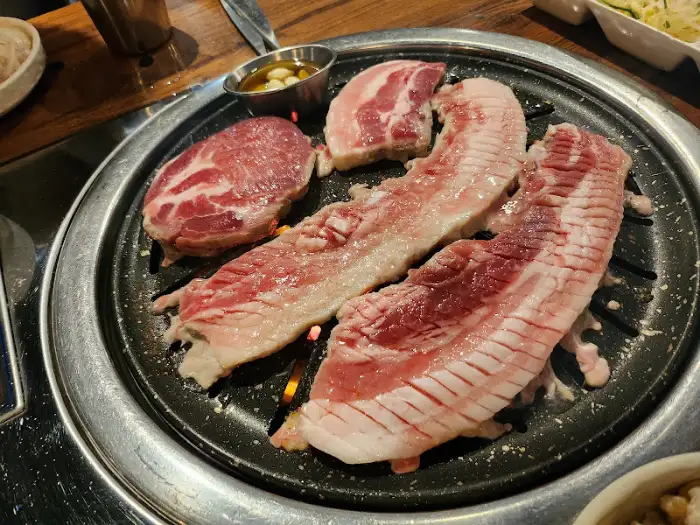 불판 위에 올라가 익어가는 삼겹살과 목살