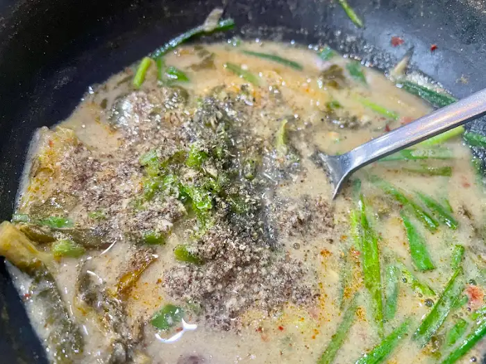 추어탕 국물에 산초가루와 들깨가루를 넣는 모습