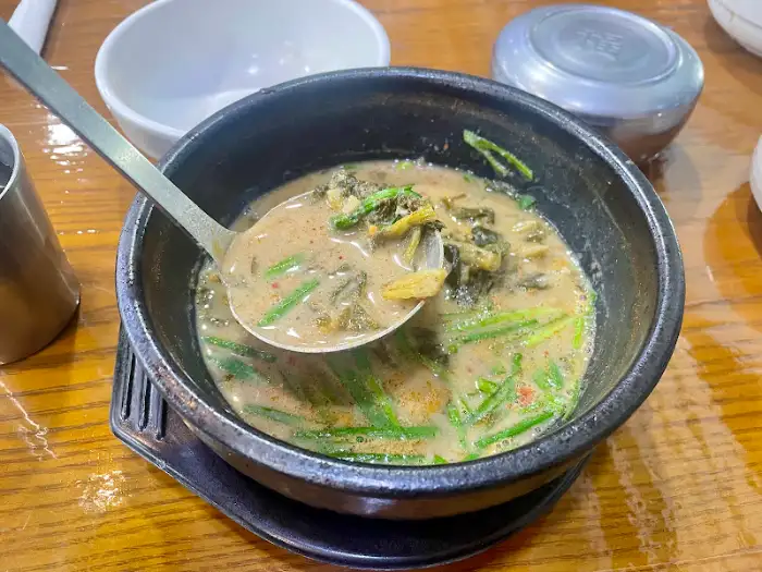 밥을 말기 전 추어탕 국물을 뜨는 모습