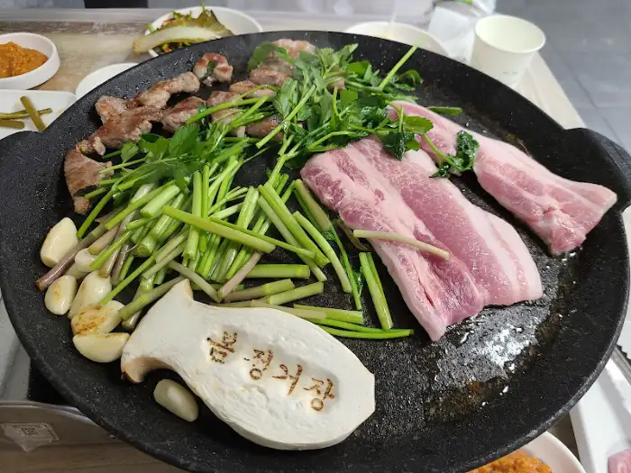 삼겹살과 미나리, 마늘 등이 함께 익어가는 모습
