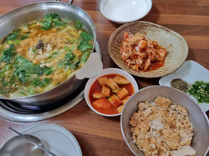 푸짐하게 차려진 어탕 칼국수 한 상. 김치, 깍두기, 누룽지까지 준비되어 있다.