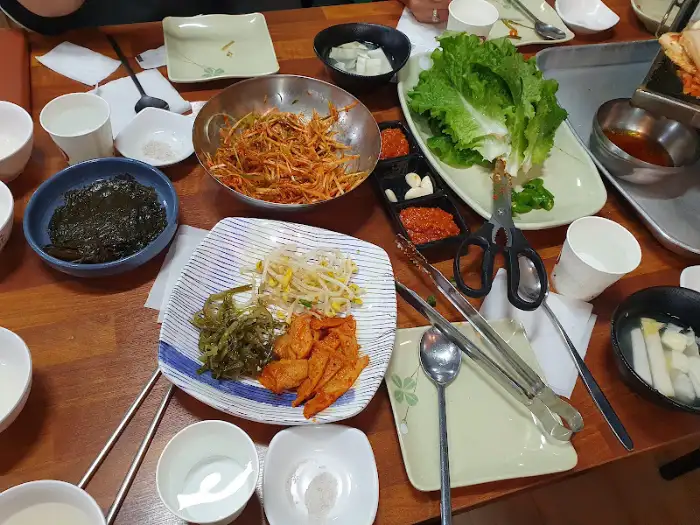 다양한 반찬과 쌈 채소가 차려진 테이블 모습