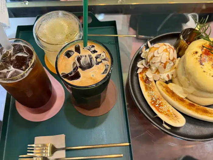 수플레 팬케이크 위에 아이스크림과 바나나가 곁들여져 있고, 커피도 함께 준비되어 있다.