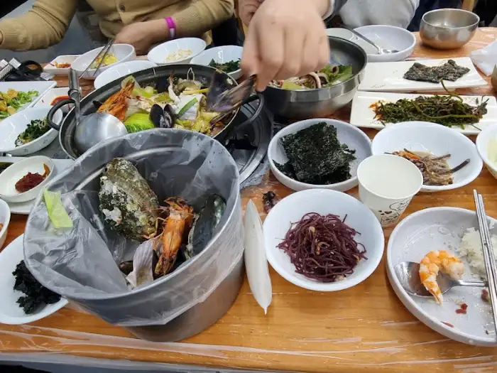 해물전골 속 재료를 가위로 자르고 있는 모습