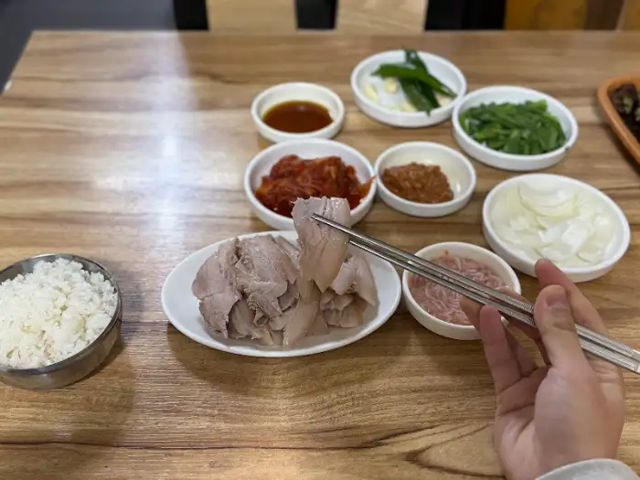 젓가락으로 집어 올린 부드러운 수육 한 점