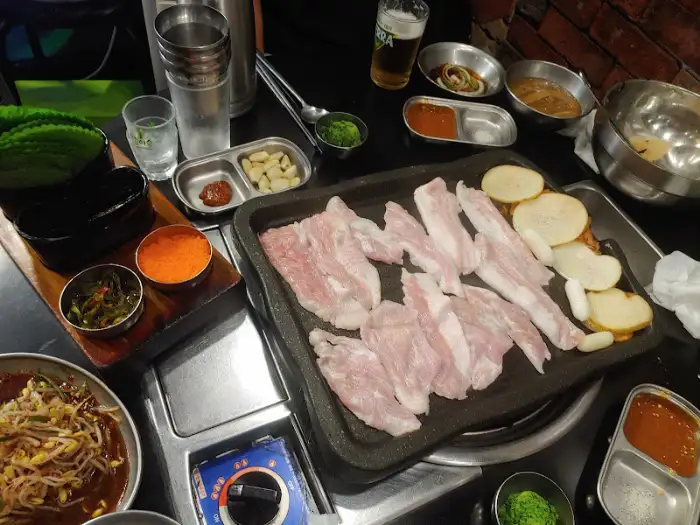 식탁 위에 정갈하게 차려진 쌈 채소와 소스들