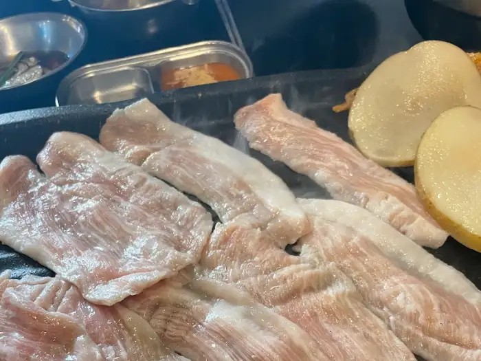 불판 위에서 맛있게 익어가는 고기와 감자