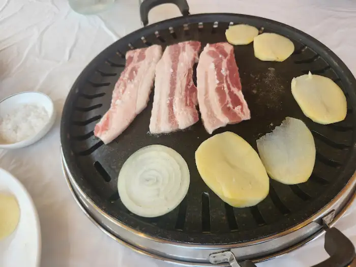 불판에 구워지는 삼겹살과 감자