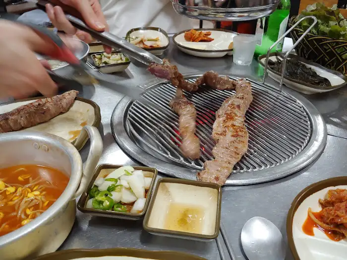 식탁 위에 차려진 다양한 고기 요리와 밑반찬