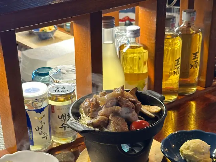 개인 화로에 담긴 흑돼지와 술병들