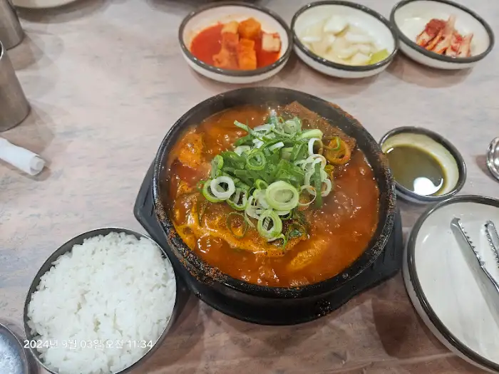묵은지와 등갈비가 푸짐하게 들어있는 찜 요리. 양념이 진하고 먹음직스러워 보인다.