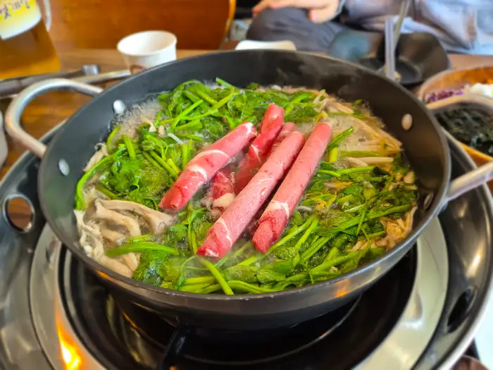 샤브샤브 육수에 면과 채소를 넣는 모습