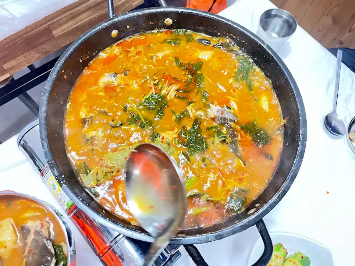끓고 있는 메기매운탕의 풍성한 재료와 국물을 클로즈업한 사진