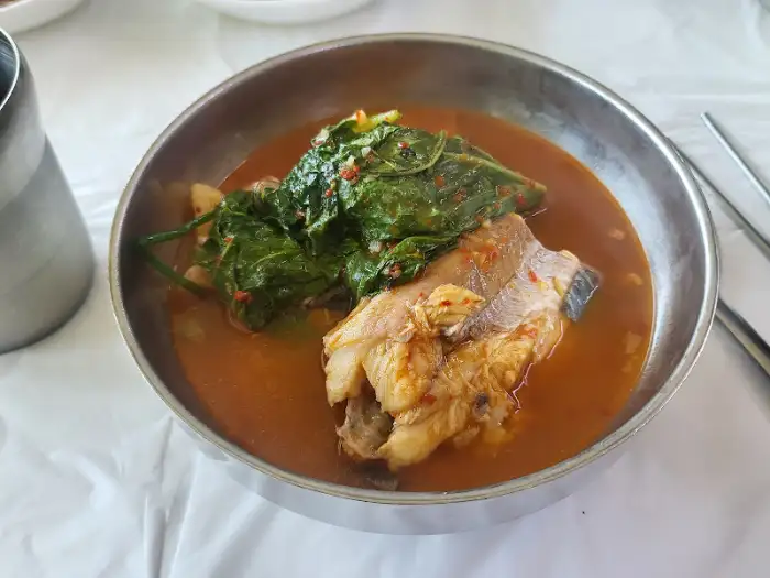 매운탕 그릇에 담긴 메기 살점과 깻잎의 조화로운 모습