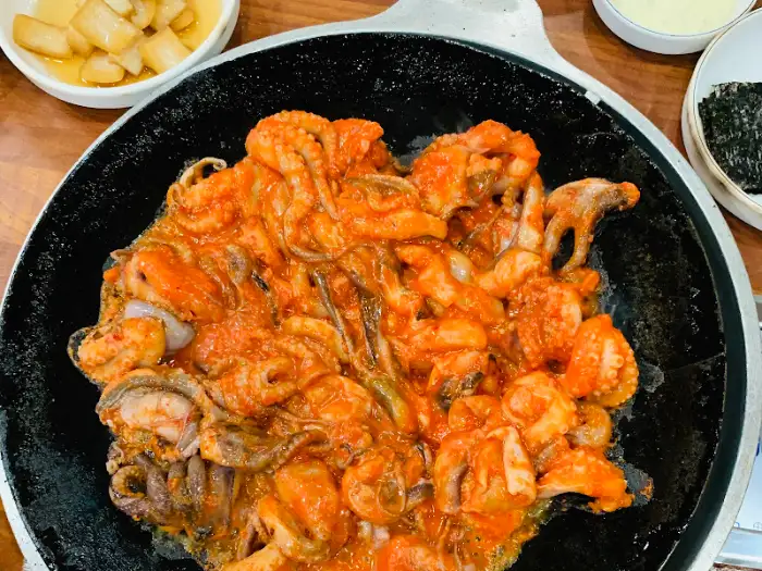 붉은 양념이 자작하게 끓고 있는 쭈꾸미 철판볶음.