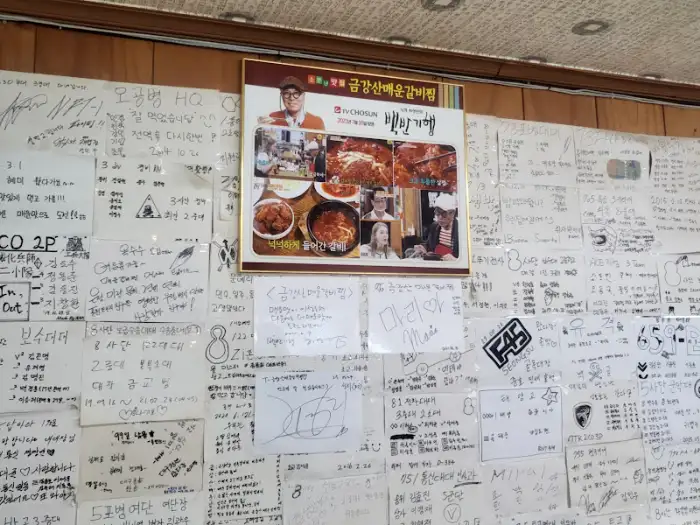 매장 벽면에 붙어있는 금강산 매운 갈비찜 관련 사진과 손님들의 메모