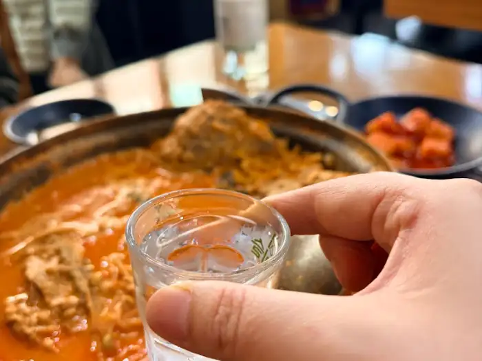 감자탕 앞에서 소주잔을 들고 있는 모습