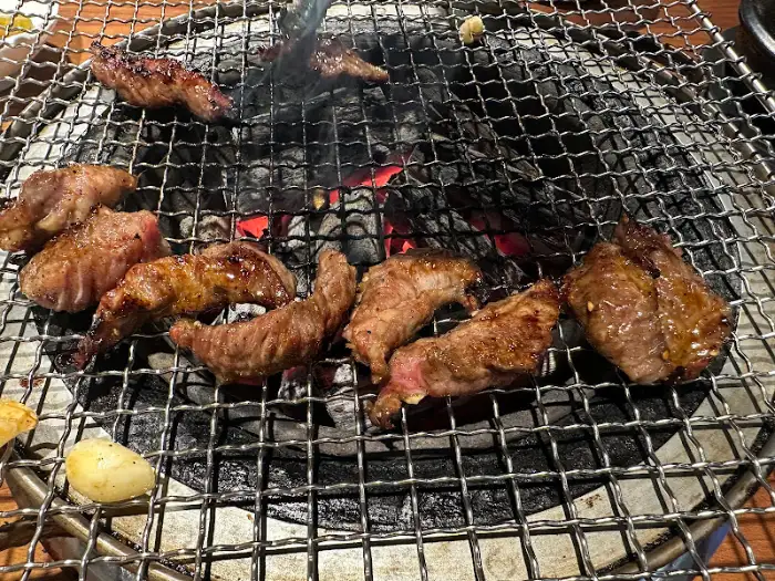 숯불 위에서 노릇하게 구워지는 고기 조각들