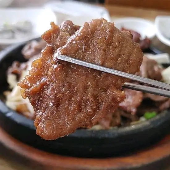 집게로 석갈비 한 점을 집은 모습