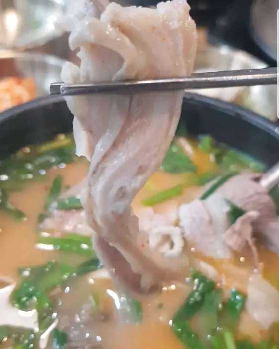 젓가락으로 돼지고기를 들어 올리는 모습