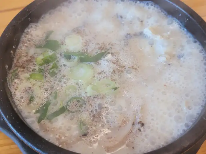 내장탕에 다대기와 고추기름을 넣어 간을 맞추는 모습