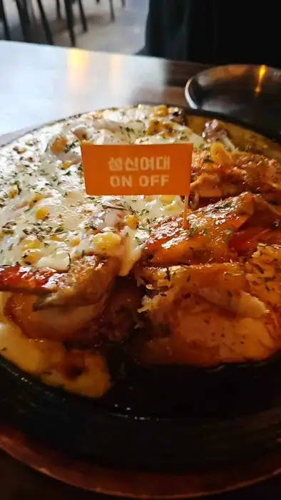 피자 한 조각을 들어 올리는 모습. 치즈가 길게 늘어나고 있다.