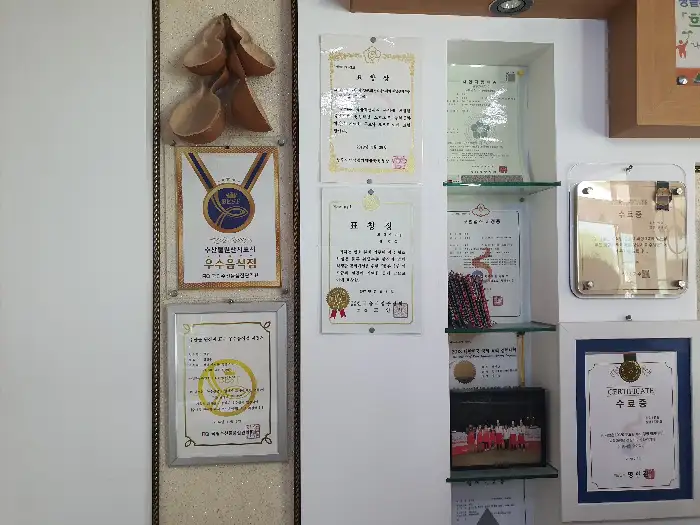 벽에 걸린 여러 개의 상장과 트로피, 액자들