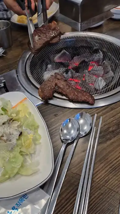 쌈 채소와 함께 소고기를 싸 먹는 모습