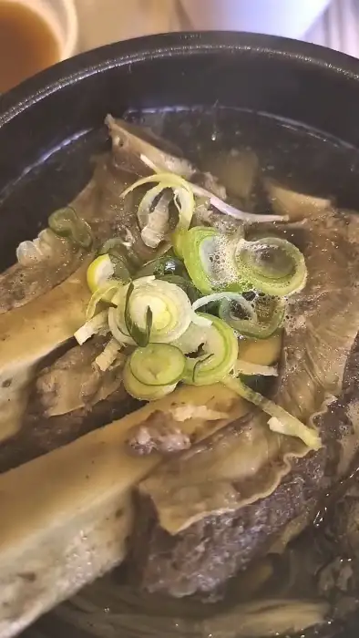 갈비탕에 담긴 부드러운 갈빗살을 젓가락으로 집어 올리는 모습