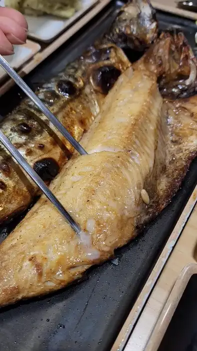 집게로 집어 올린 촉촉한 생선 살