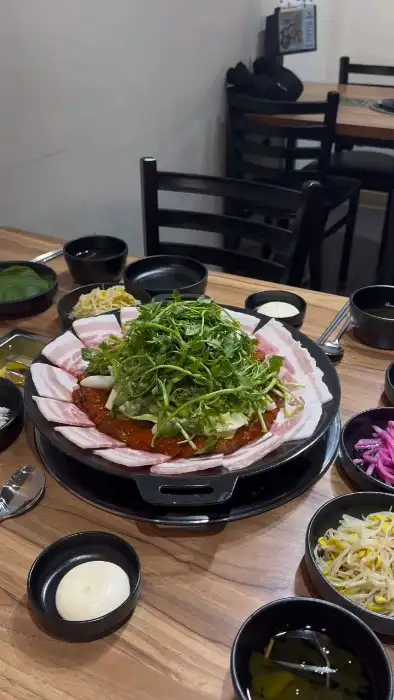 쭈꾸미 철판볶음 위에 덮여 나온 얇게 썬 삼겹살