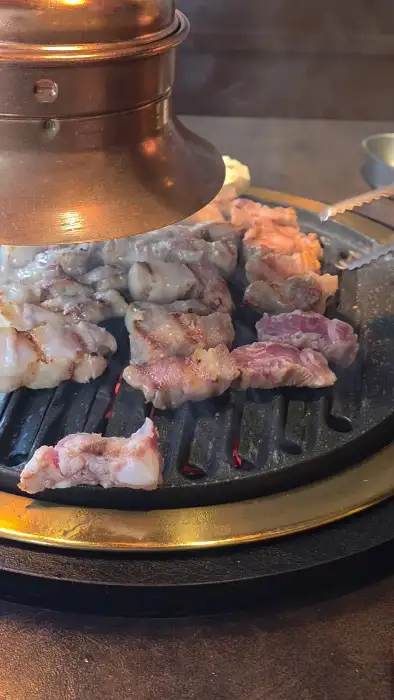 불판 위에서 익고 있는 고기와 떡, 버섯
