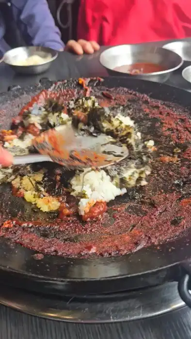 철판에 볶아진 볶음밥 위에 김가루와 치즈가 뿌려진 모습